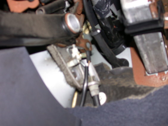 Close-up of a vehicle's parking brake assembly with cables and metal components