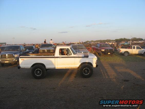 White pickup truck with lifted suspension, side view. Appears to be from the late 1970s