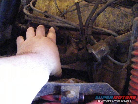 Hand pointing to engine components