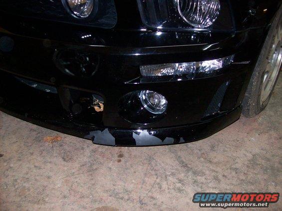 Black car front bumper with peeling paint and fog lights