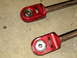 1996 Ford Bronco - Close-up of two red suspension components with visible ball joint assemblies.
