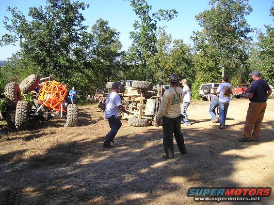 Overturned off-road vehicle with people gathered around