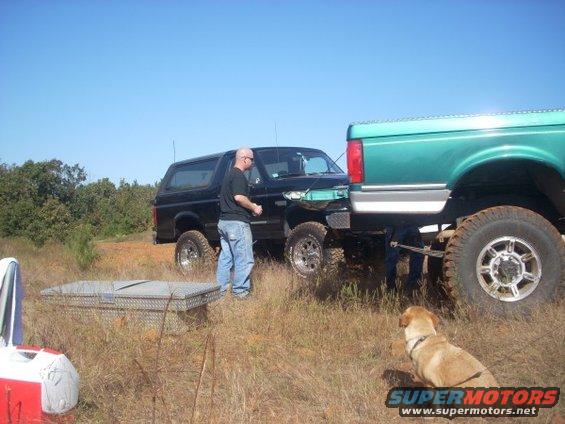 Black 1992 Ford Bronco 3q-front view next to a green truck