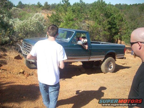 Green pickup truck with aftermarket bumper, side view