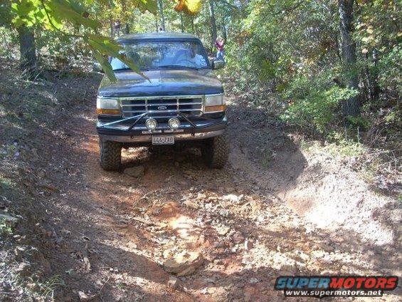 Black 1992 Ford Bronco driving on a dirt trail