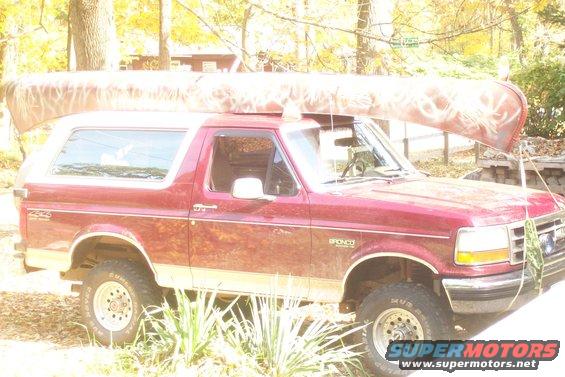 Red 1993 Ford Bronco with canoe on roof