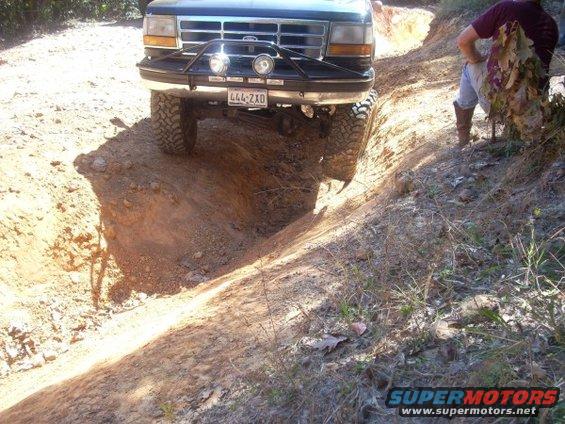 Ford F-Series truck going off-road, front bumper and grille visible. License plate 444-ZXD
