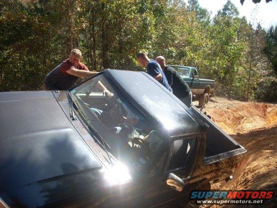 1992 Ford Bronco stuck in a ditch, being pushed by people