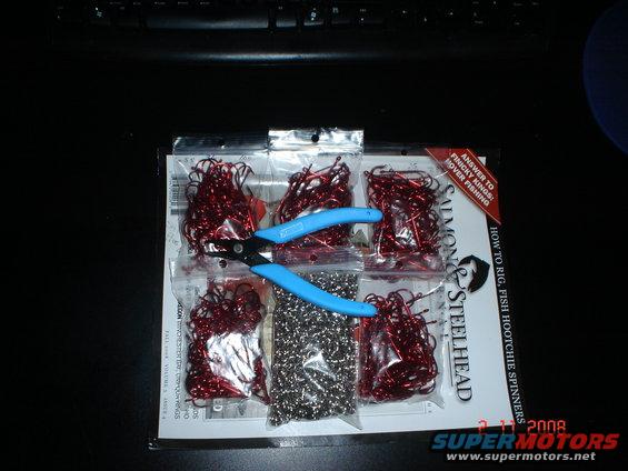 Fishing tackle kit with red hooks and beads, plus blue pliers