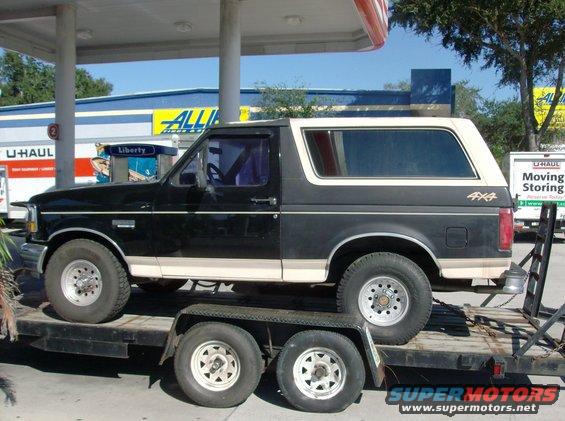 Black 1992 Ford Bronco on a trailer, side view, beige trim, 4x4 decal