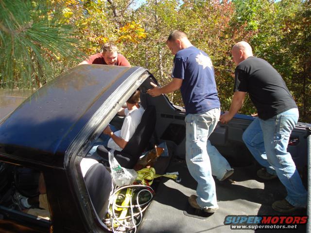 Black vehicle interior with people pushing it from the outside