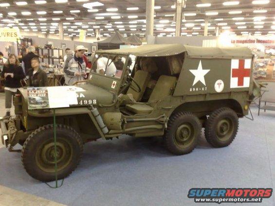 Olive drab six-wheeled military ambulance with white star and red cross insignia, 290-67 markings