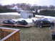 1998 Chevrolet Tahoe - Two snowmobiles are loaded onto a trailer, hitched to a black SUV in a snowy yard.