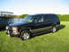 1998 Chevrolet Tahoe - A black SUV is parked on a grassy lawn with a wooden deck in the background.