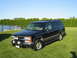 1998 Chevrolet Tahoe - This 1998 Chevrolet Tahoe is presented in a three-quarter front view, its black exterior and added bull bar with fog lights.