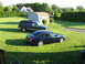1998 Chevrolet Tahoe - Two vehicles are parked on a lawn in front of a residential house and a shed.