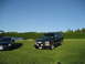1998 Chevrolet Tahoe - A black 1998 Chevrolet Tahoe is parked on a lawn next to another vehicle under a clear blue sky.