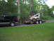 1998 Chevrolet Tahoe - A black 1998 Chevrolet Tahoe is seen from the side, towing a trailer loaded with a skid steer loader.