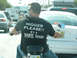 1995 Dodge 1500 - A man rides a motorcycle through traffic while wearing a t-shirt with offensive text.
