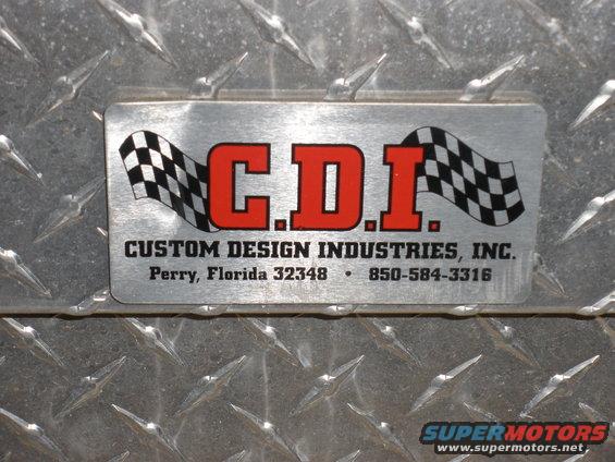 Metal plate with C.D.I. Custom Design Industries, Inc. logo and contact info