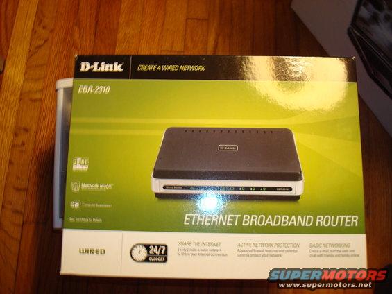 D-Link EBR-2310 Ethernet Broadband Router box on a wooden surface. The box is green and white with a picture of the router