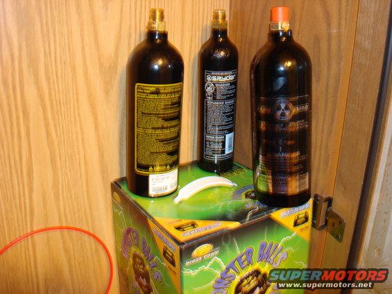 Three dark compressed air tanks sit on top of a box labeled 'Monster Balls'