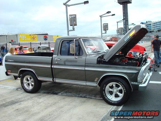 Gray 1970s Ford F-Series pickup truck with hood open, parked outdoors
