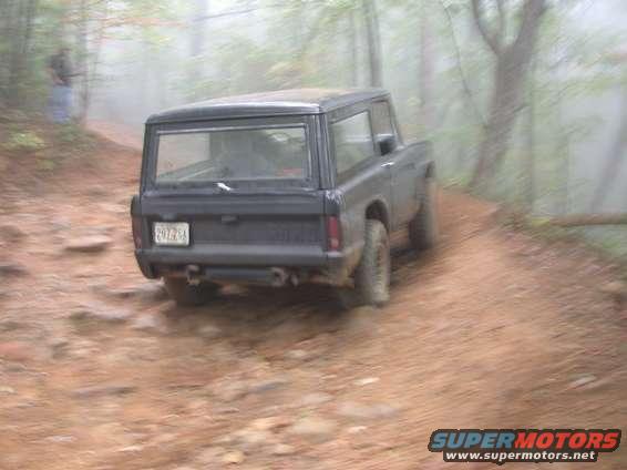 Black 1972 Ford Bronco rear view on a dirt road