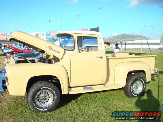Cream-colored Ford F-series truck with hood open, parked on grass
