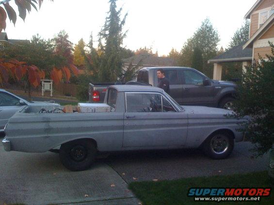 Gray pickup truck with a bed, seen from the side. It has a single cab and appears to be undergoing restoration
