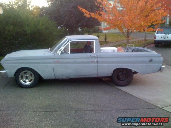 Gray 1960s pickup truck, side view. Another vehicle is parked in the background