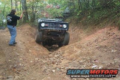1972 Ford Bronco front view navigating a steep dirt rut