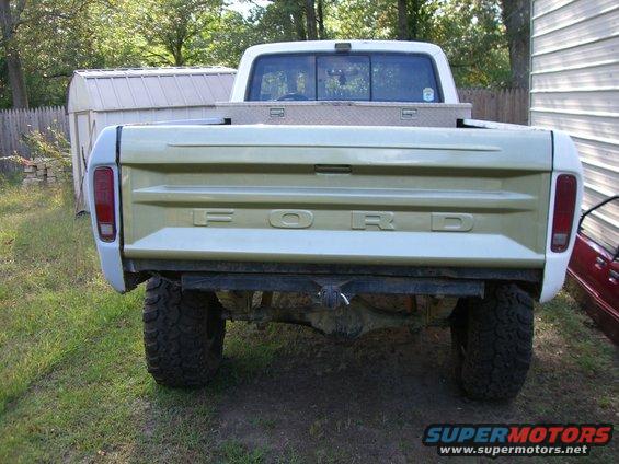Rear view of a 1970s Ford pickup truck with a gold tailgate and white fenders