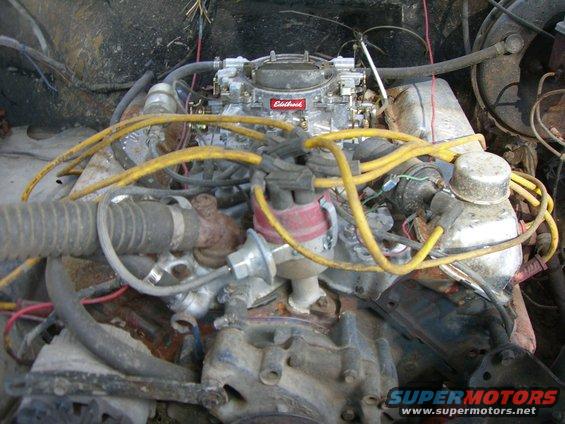 Engine bay with a carburetor and yellow spark plug wires