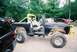 1972 Ford Bronco - A modified black Ford Bronco sits outdoors with a person inside, showing its lifted suspension and off-road tires.