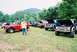 1972 Ford Bronco - A collection of Ford Broncos are gathered outdoors, with a staff member visible near a red model.