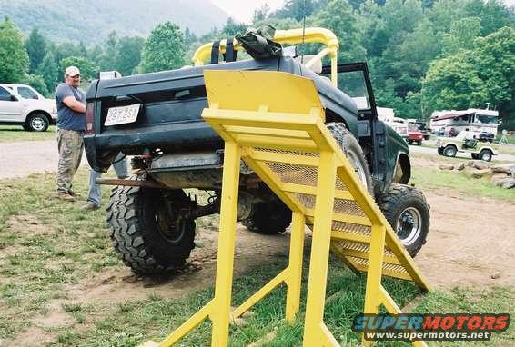 1972 Ford Bronco rear view with yellow ramp and a man standing nearby