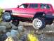 1998 Jeep Cherokee - This red 1998 Jeep Cherokee navigates a rocky trail, its off-road capabilities.