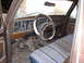1978 Ford Bronco - The interior of this truck features a brown dashboard and a patterned bench seat.
