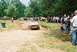 1972 Ford Bronco - A Jeep CJ-5 navigates a muddy obstacle course as a crowd observes the event.