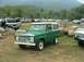 1972 Ford Bronco - A green 1970 Ford Bronco is parked in a field with several other vehicles and trees in the background.