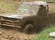 1972 Ford Bronco - Muddy 1972 Ford Bronco navigating a challenging off-road course.