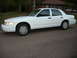 2001 Ford Crown Victoria - A white 2001 Ford Crown Victoria sedan is parked on a residential street.