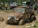 1972 Ford Bronco - Multiple off-road vehicles navigate a muddy terrain, with one prominently stuck in a mud pit.