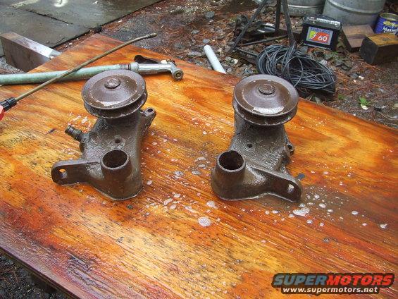Two brown car water pumps on a wet wooden surface