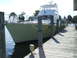 1976 Ford F-150 - A yacht is tied to a wooden dock on a sunny day.