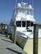 1976 Ford F-150 - A white and tan yacht is moored to a wooden pier under a clear blue sky.