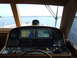 1976 Ford F-150 - The helm of a boat shows multiple navigation screens displaying charts and data, with the open water visible through the windows.
