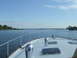1976 Ford F-150 - View from the bow of a boat sailing on a tranquil bay, with trees and houses visible on the distant shore.