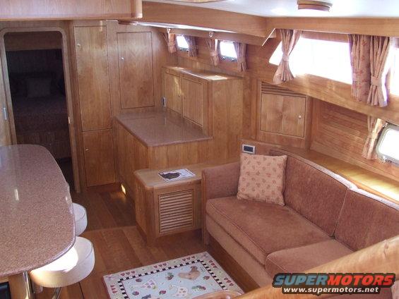 Yacht interior with wood paneling, a brown sofa, and a small table